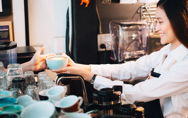 Poster - Barista served hot coffee to customer with smiling face at counter bar in cafe restaurant,coffee shop business owner concept,Service mind waitress.