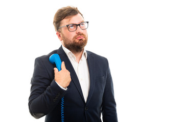 Wall Mural - Portrait of business man holding blue receiver and thinking.