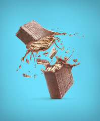 Sticker - Wafers are broken into pieces, with a chocolate splash, on a blue background