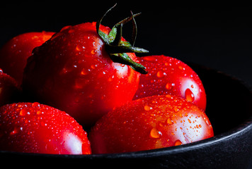 Fresh red tomato in wooden cup healthy food and vegetable concept on black background