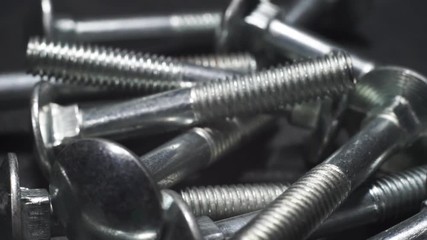 Poster - Bolts rotating on a white wooden table  background. Macro view,