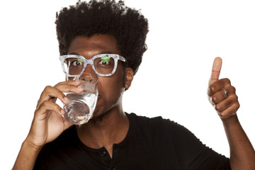 Portrait of young african american man drinking water from a glass  on white background