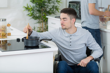 disabled young man is cooking a meal in the kitchen