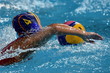 Waterpolo player swimming with ball in the pool.