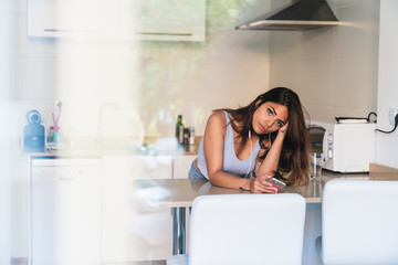 Young brunette listening to music in kitchen