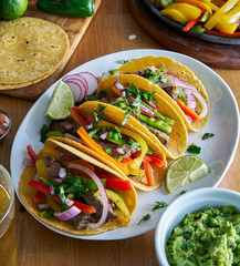 Wall Mural - mexican fajita tacos in yellow corn tortilla served with guacamole