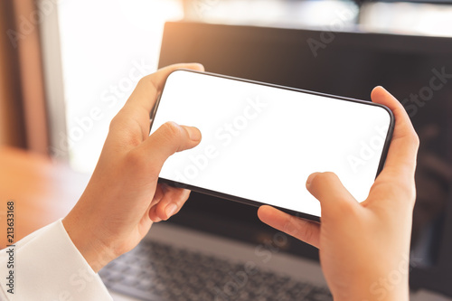 Fotomural Woman hands using horizontal white screen smartphone mockup for graphic display montage