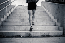 Black And White Closeup Of Young Man Running Up The Stairs With Running Clothes