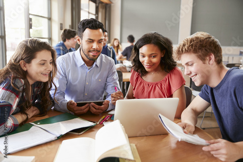 High School Students Using Laptops And Digital Tablets Working