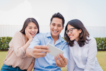 Wall Mural - Asian friends having fun watching things on smartphone