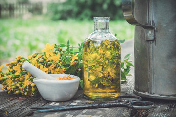 Wall Mural - Hypericum - St Johns wort plants, oil or infusion transparent bottle, mortar on wooden table.