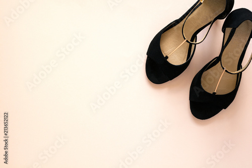 Photographie Stylish classic black women's leather sandals shoes with high heels on pink purple multi-colored paper background