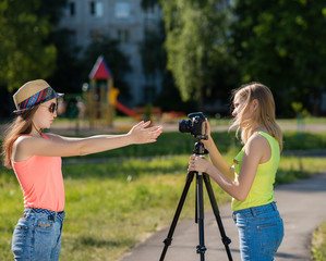 Two girls girlfriend. Summer in nature. Writes video to the camera. Record vlog and blog. Record video lesson for Internet. Use camera with tripod.