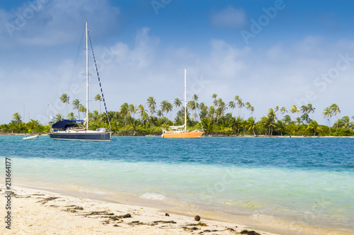 A Small Boat Floating Near The Coast Of A Caribbean Island Clear