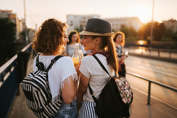 Wall Mural - Two gorgeous girls having fun while walking to a music festival in the summer.