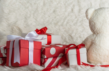 Wall Mural - pile of gift boxes and teddy bear on white wool background