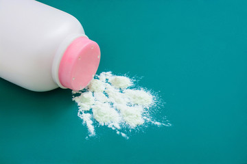 Baby talcum powder container on green background with copy space