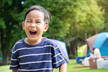 Close up portrait of a happy little boy smiling at park. Selective focus image.