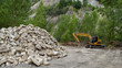 exacavator in the marble quarry with heap of rocks,industrial site