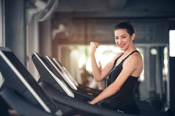 Wall Mural - Sport Caucasian Woman on Treadmill Showing Her Muscle with Happy to Workout and Exercises in Gym - Lifestyle Concept