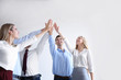 © Africa Studio - Young people in office wear putting hands together on light background. Unity concept