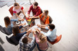 © Africa Studio - Young people holding hands while working on project indoors. Unity concept