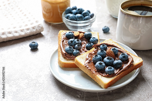 Fotografía Toast bread with blueberries and chocolate paste on table