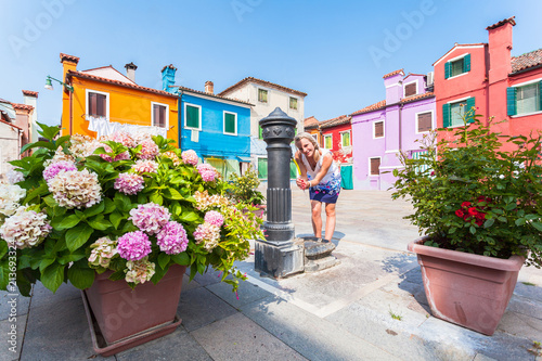 Fototapeta uliczka z kwiatami   malownicze-patio-z-kolorowymi-domkami-na-wyspie-burano-z-hortensjami-w-doniczkach-i-a