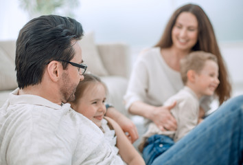 Wall Mural - close up.parents and their small children sitting on the couch