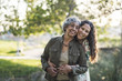 © Cavan Images - Portrait of smiling daughter embracing mother while standing outdoors