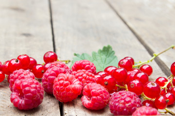 Red berries on an old board. Summer background.