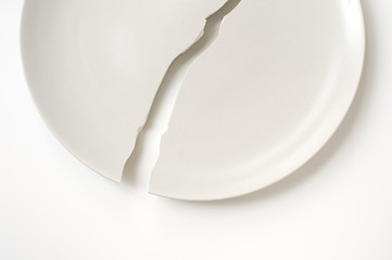 Cracked plate on white table.