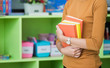 © weedezign - Teacher holding learning look at library in kindergarten preschool.education concept.