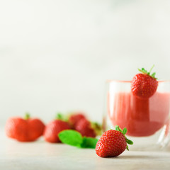 Wall Mural - Glass with vegan strawberry smoothie on grey background with copy space. Square crop. Summer food and clean eating concept, vegan diet. Pink detox beverage with fresh berries