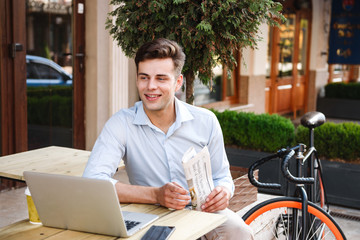 Poster - Happy young stylish man in shirt holding newspaper