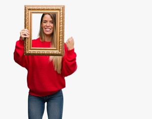 Sticker - Beautiful young woman holding vintage frame screaming proud and celebrating victory and success very excited, cheering emotion