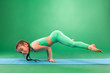 © Mike Orlov - Kid girl doing fitness exercises on green background