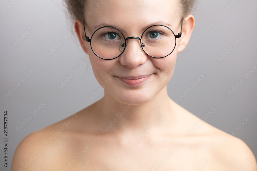 modest nude girl in round glasses on the isolated white background