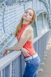 © rogkoff - Beautiful young girl with long hair dreamily waiting at the bridge