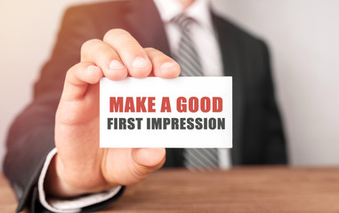 Poster - businessman holding a card with text make a good first impression