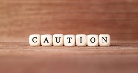 Poster - Word CAUTION made with wood building blocks