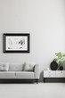 © Photographee.eu - Photo in a black, thick frame on a gray wall, white sideboard and a gray sofa in a in a stylish living room interior with place for a coffee table.