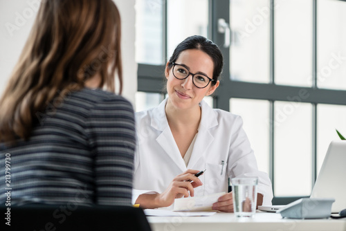 Fotografía Female physician listening to her patient during consultation while sitting down