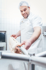 Butcher taking sausages he processed away on beam