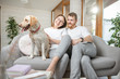 © rh2010 - Portrait of a lovely couple sitting with their happy dog on the couch at home