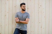 Handsome Tall Arabian Beard Man Model At Stripped Shirt Posed Outdoor Against Wooden Background. Fashionable Arab Guy.