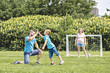 © Louis-Photo - Man with child playing football outside on field