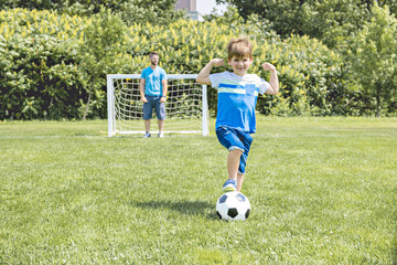 Wall Mural - Man with child playing football outside on field