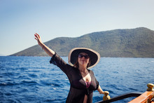 Beautiful Girl In Hat Relaxing On The Boat And Looking At The Island. Travelling Vocation Tour In Turkey