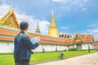 Young man traveler looking the Map in Wat Phra kaew at Bangkok Thailand. Traveling in Bangkok Thailand
